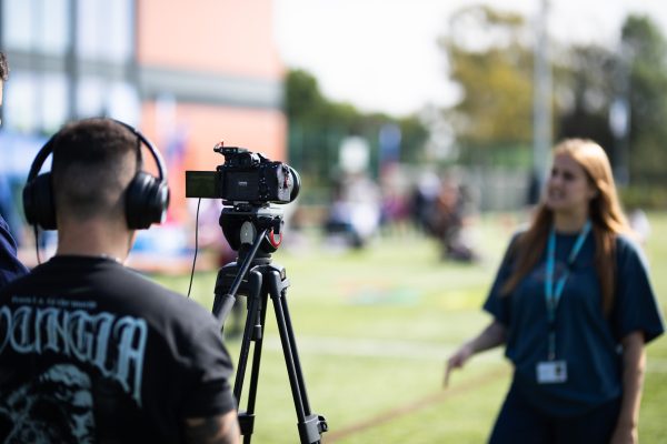 A camera pointing towards a group of young people doing sport.