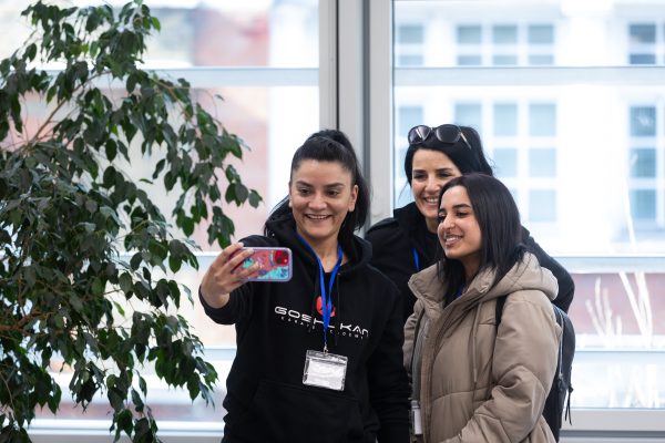 Three young women at the StreetGames awards taking a selfie in front of a window.