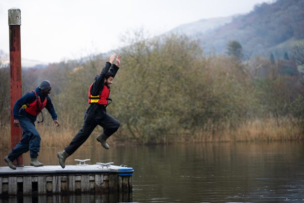 Zain - StreetGames young advisor, jumping into a body of water, wearing a lifejacket and water proof clothing